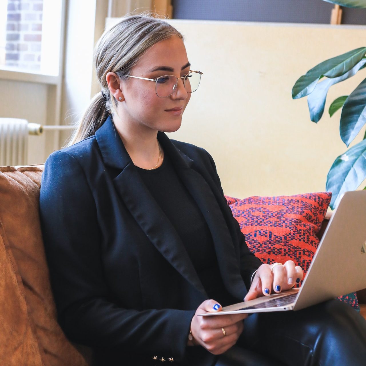 woman in black blazer using macbook